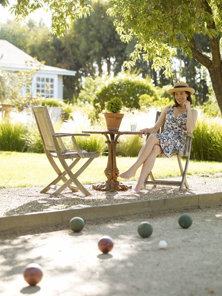 Woman in sundress sitting on outdoor patio